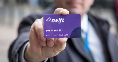 a man holding a purple swift pay as you go card