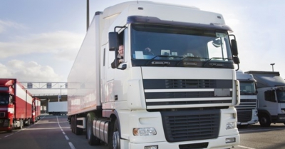 a white hgv on the road with driver at the window