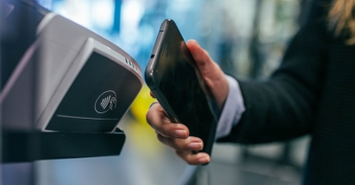 A phone is held up to a contactless reader